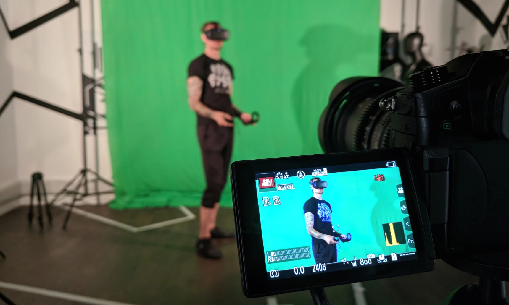 a man using VR being filmed in front of a green screen