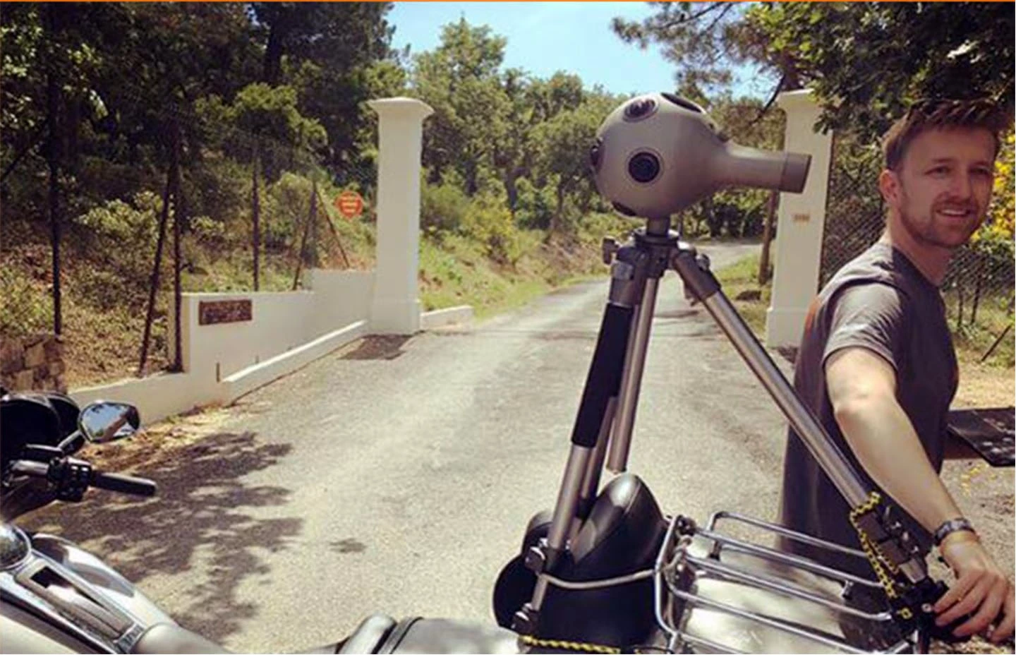 Man rigging 360 camera to the back of a Harley Davidson motorbike