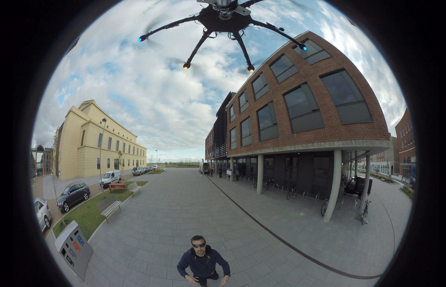 Man below drone capturing 360 footage of buildings