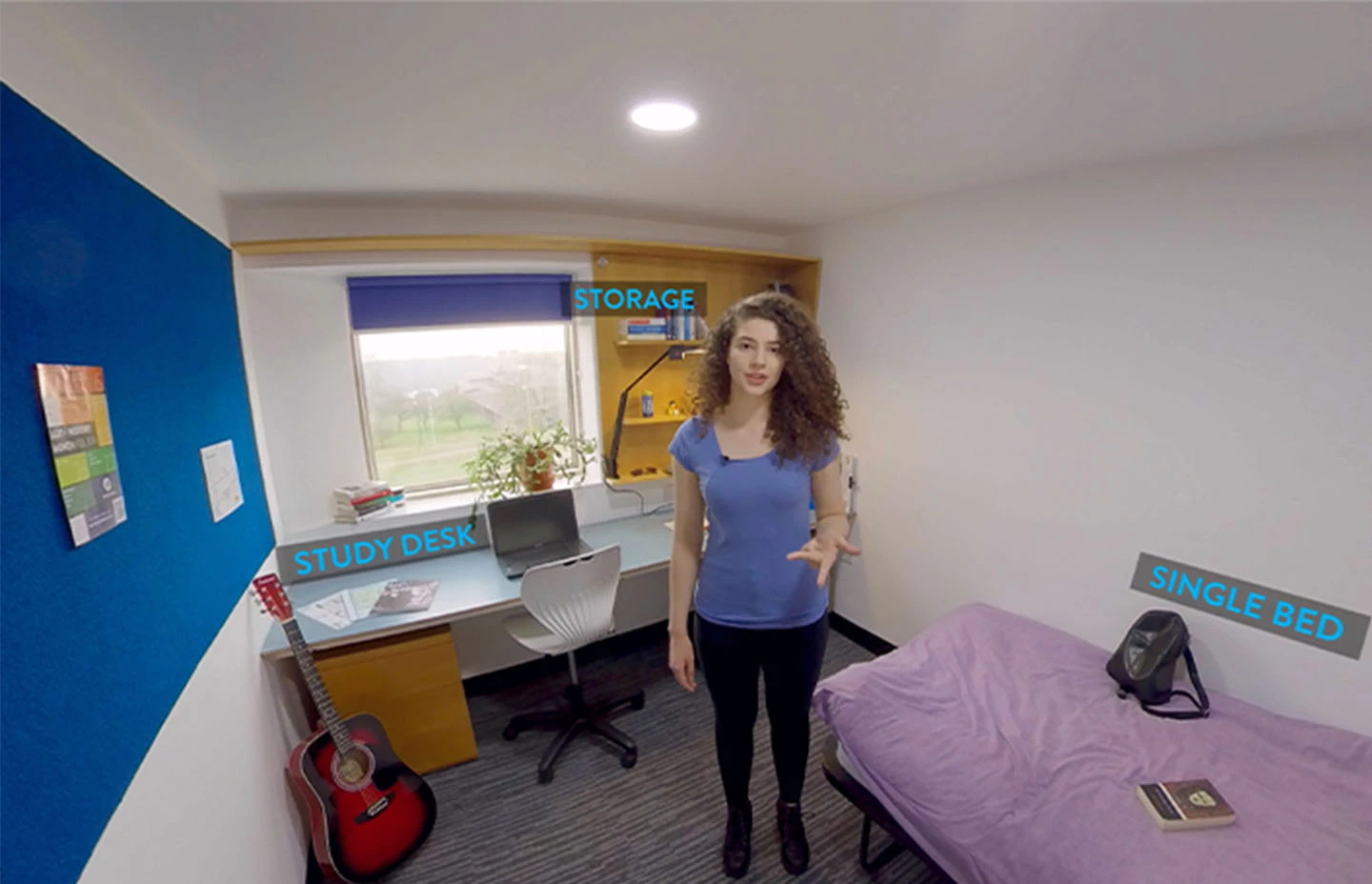 Student standing in student accommodation describing room amenities