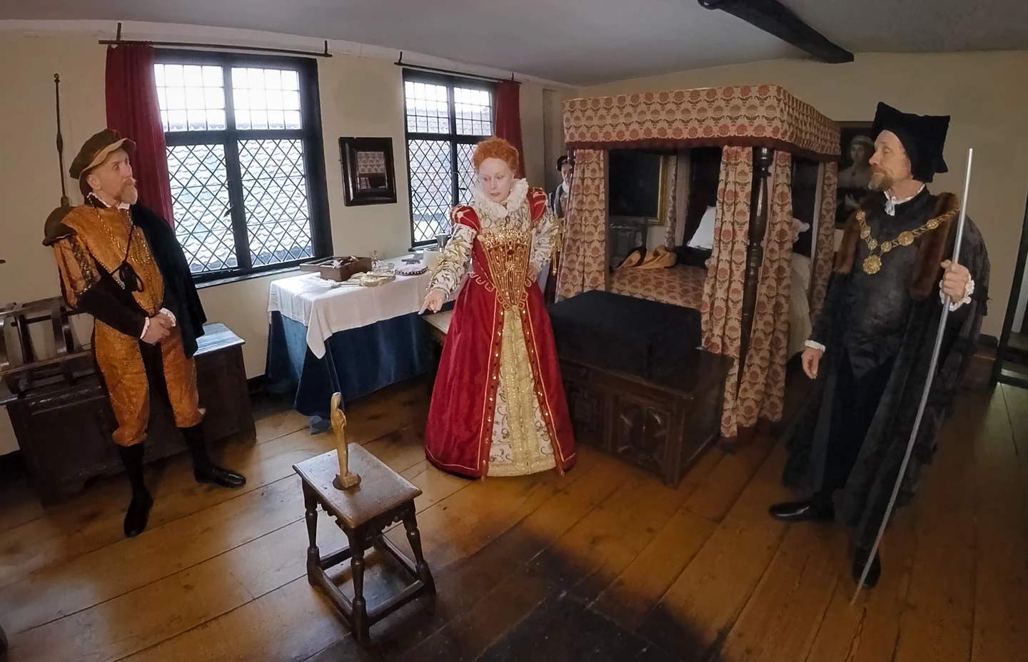 Elizabeth the First flanked by servants in a bedroom