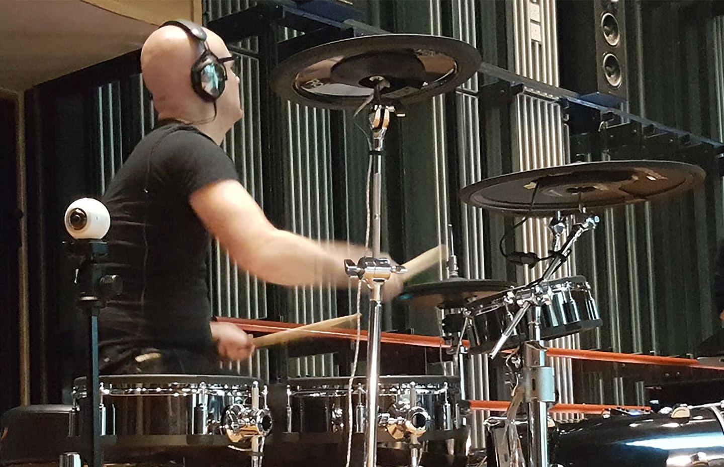 a drummer playing and wearing headphones