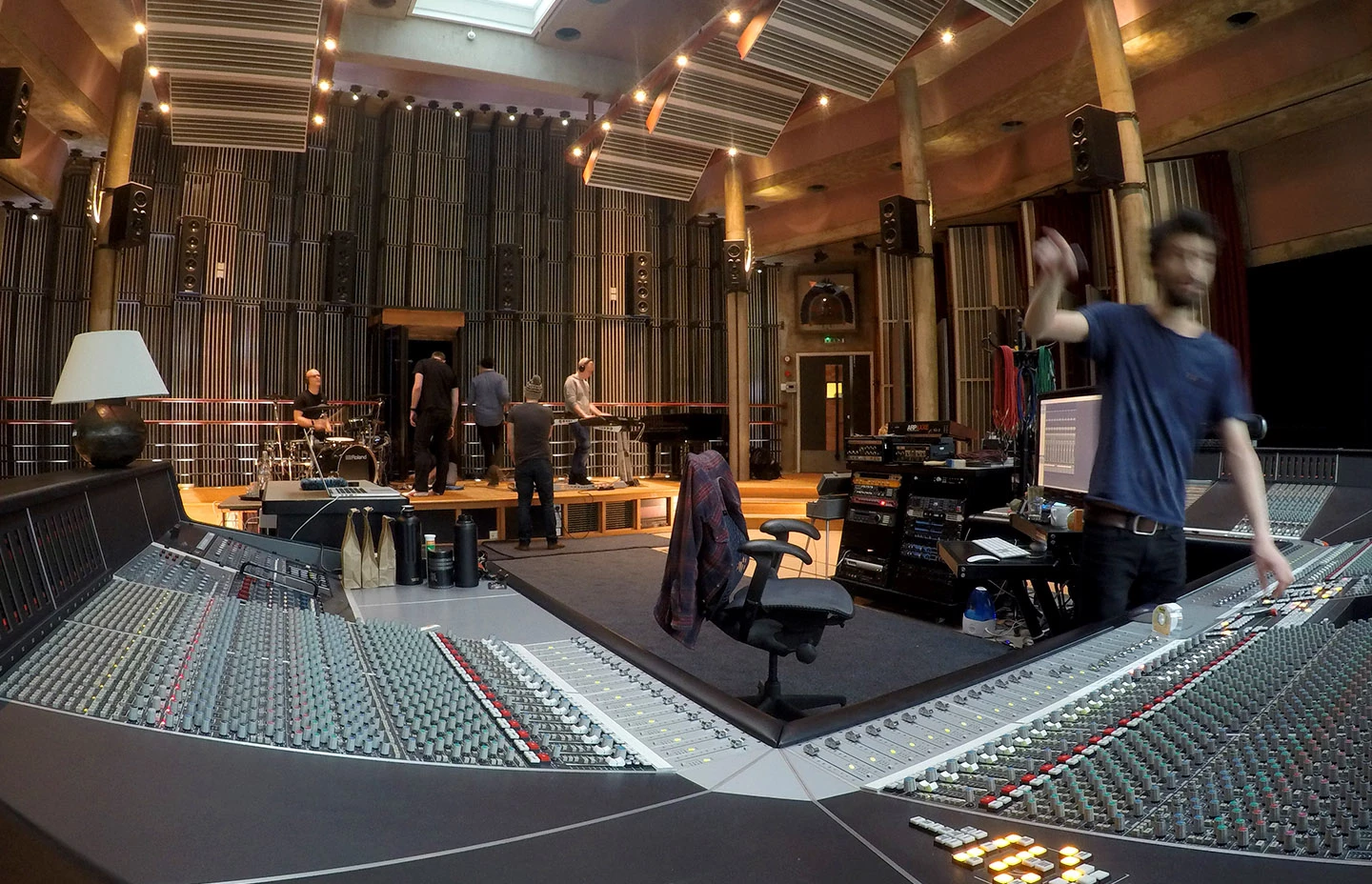 An image of a recording studio in use with a man at a mixing desk