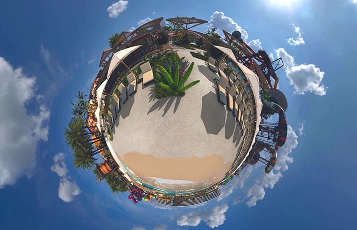 A picture of a beach warped to look like a small planet against the sky