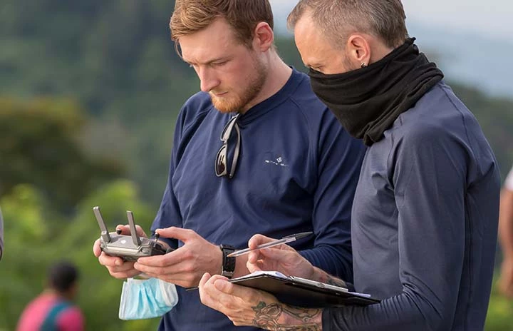 two men reviewing footage recorded on a drone